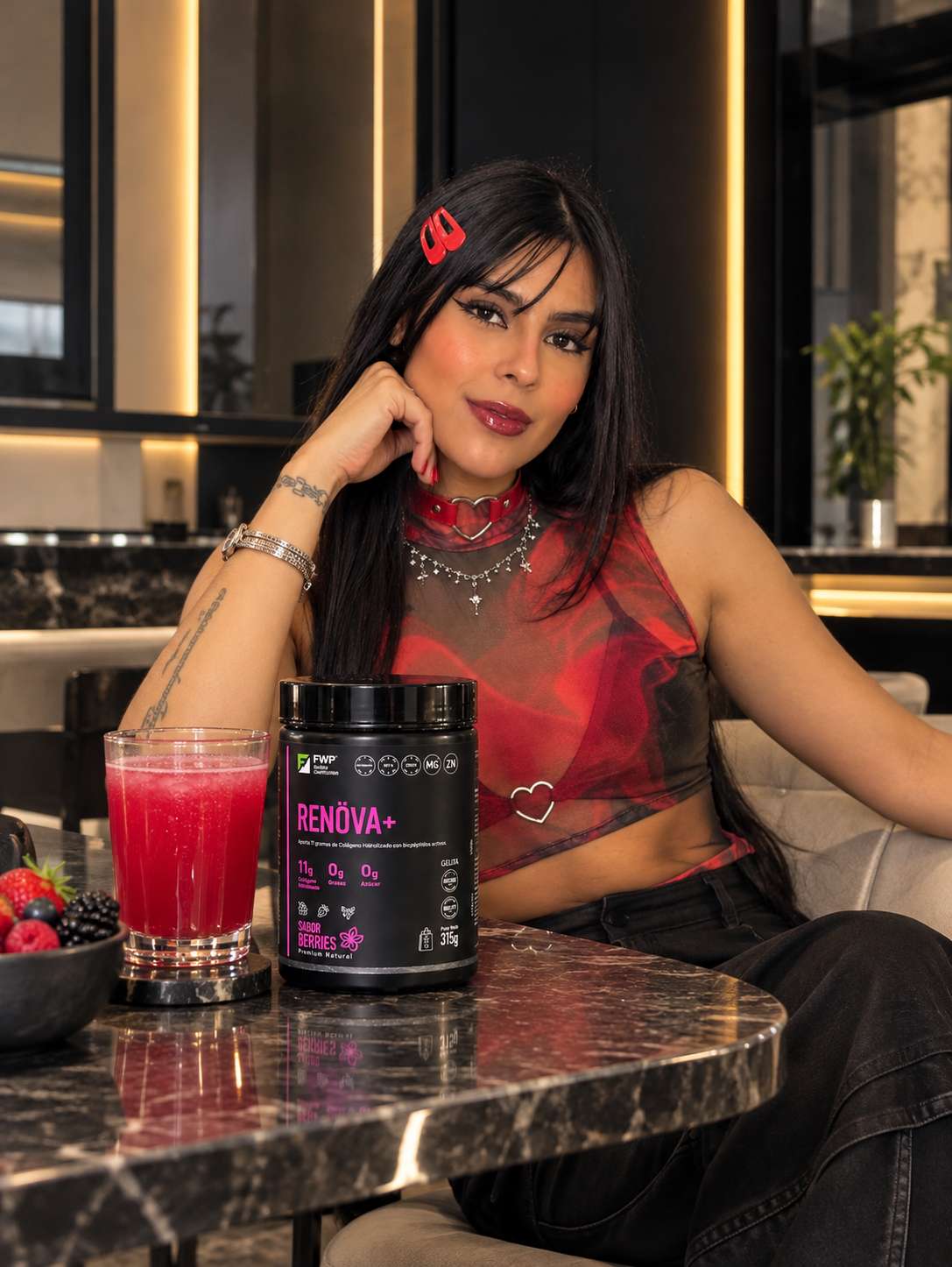 Camila sentada junto a una bebida y un envase Renova